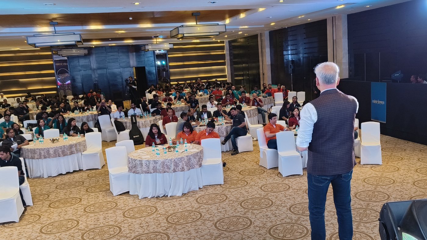 Sanjay Kanakia addressing a full hall at a company event